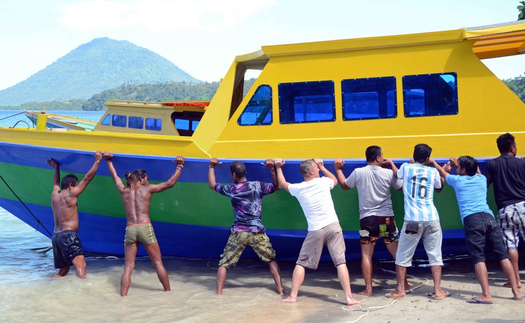 Holding the boat upright as it moves into the sea