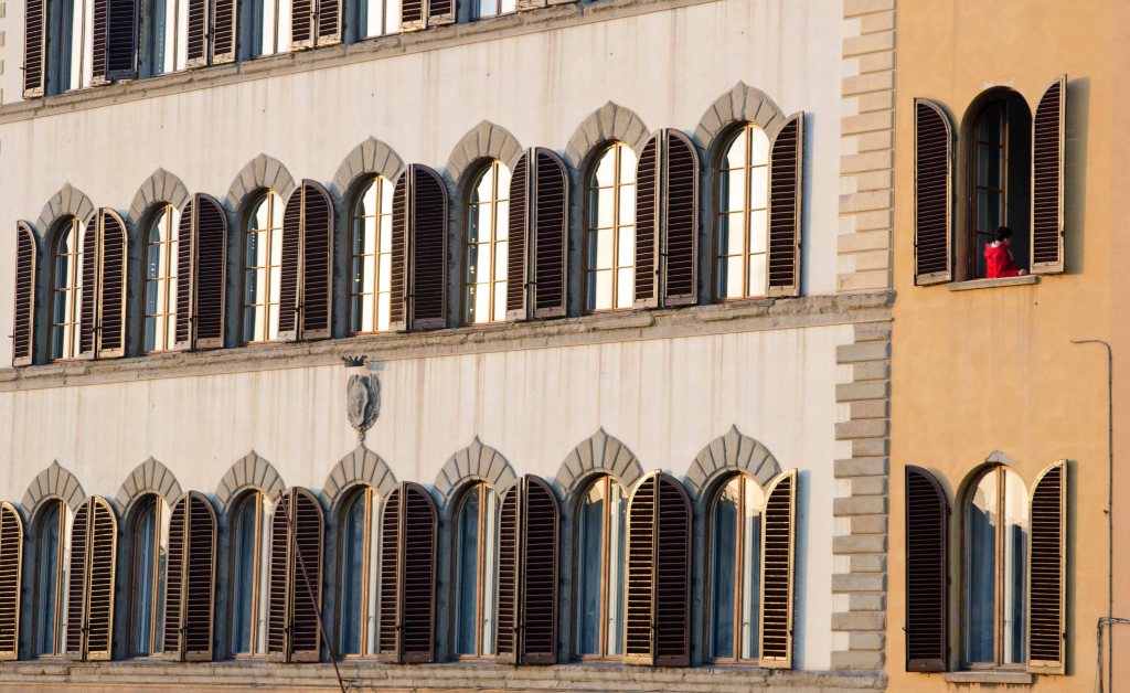 Boy in red jacket at the window, River Arno, Florence