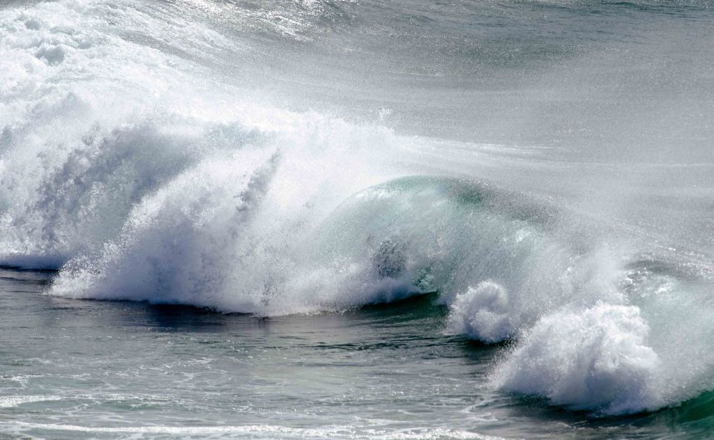 Surfing at Esterio beach; surfer encased by breaking wave.