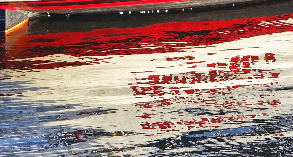 A yacht name reflected in the water