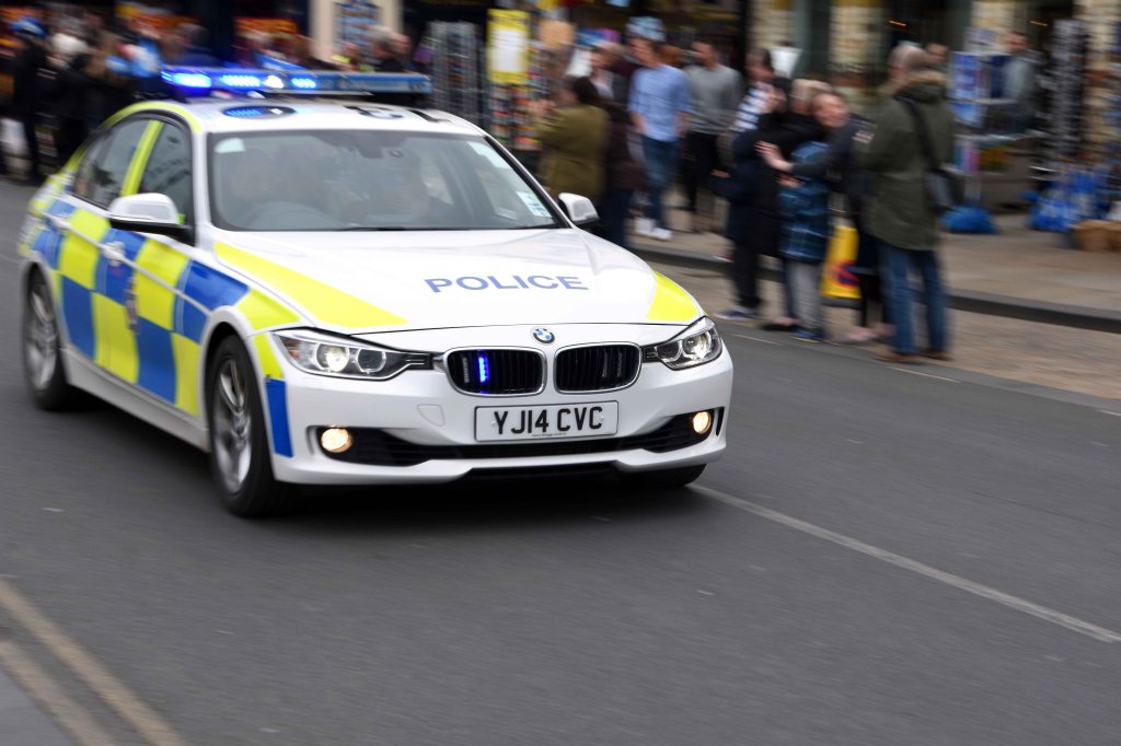 Police car in front of riders